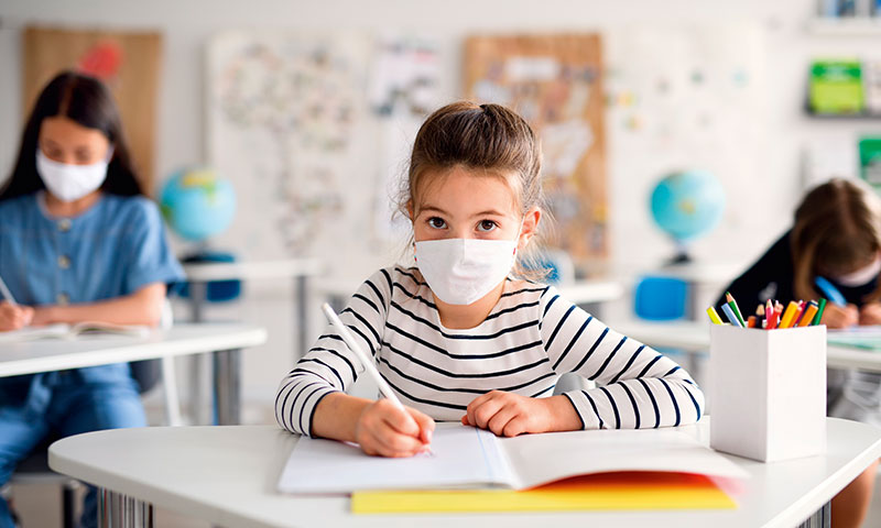 Kinder mit Maske im Klassenzimmer